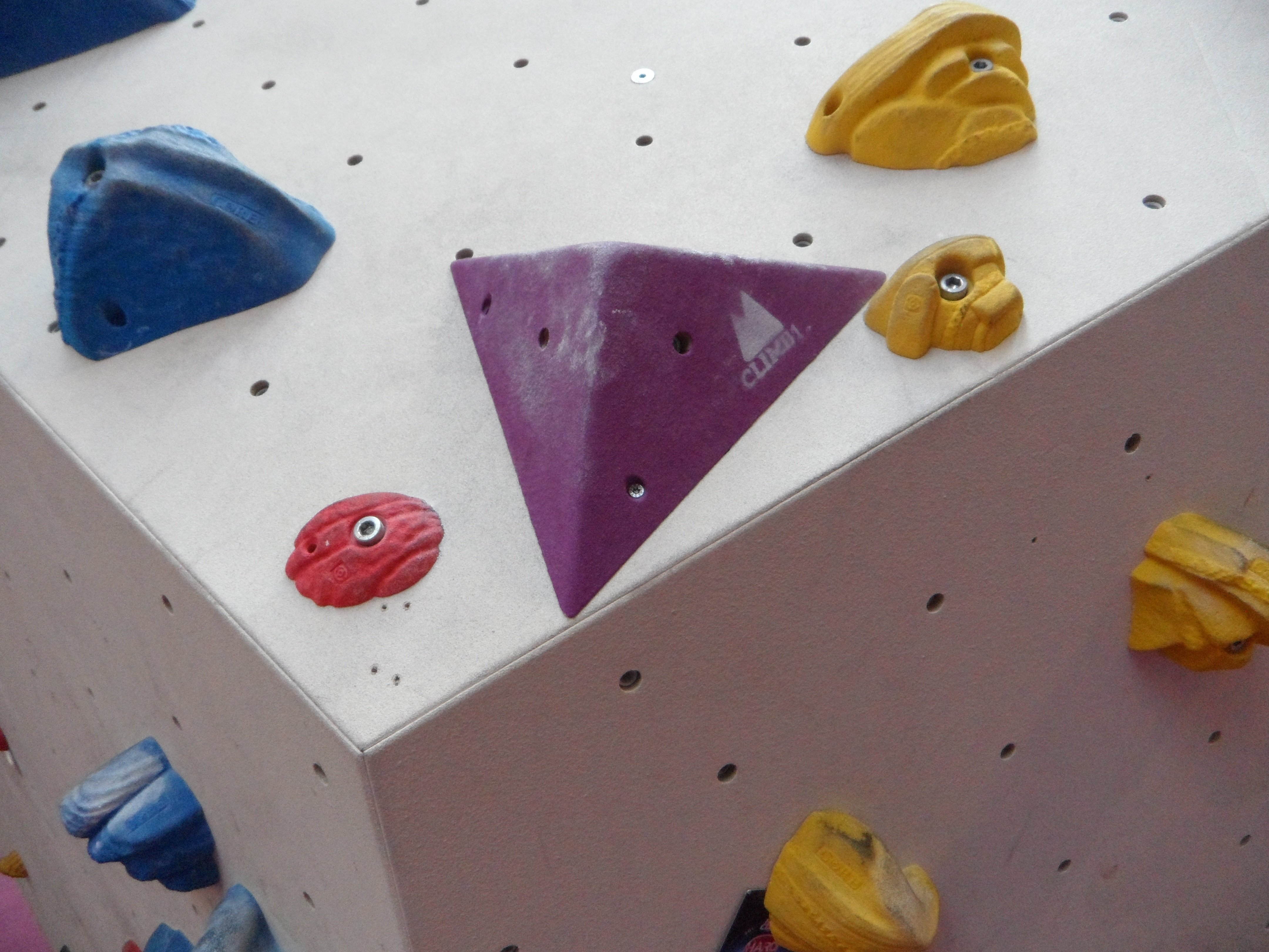 Farverige klatregreb på en boulder